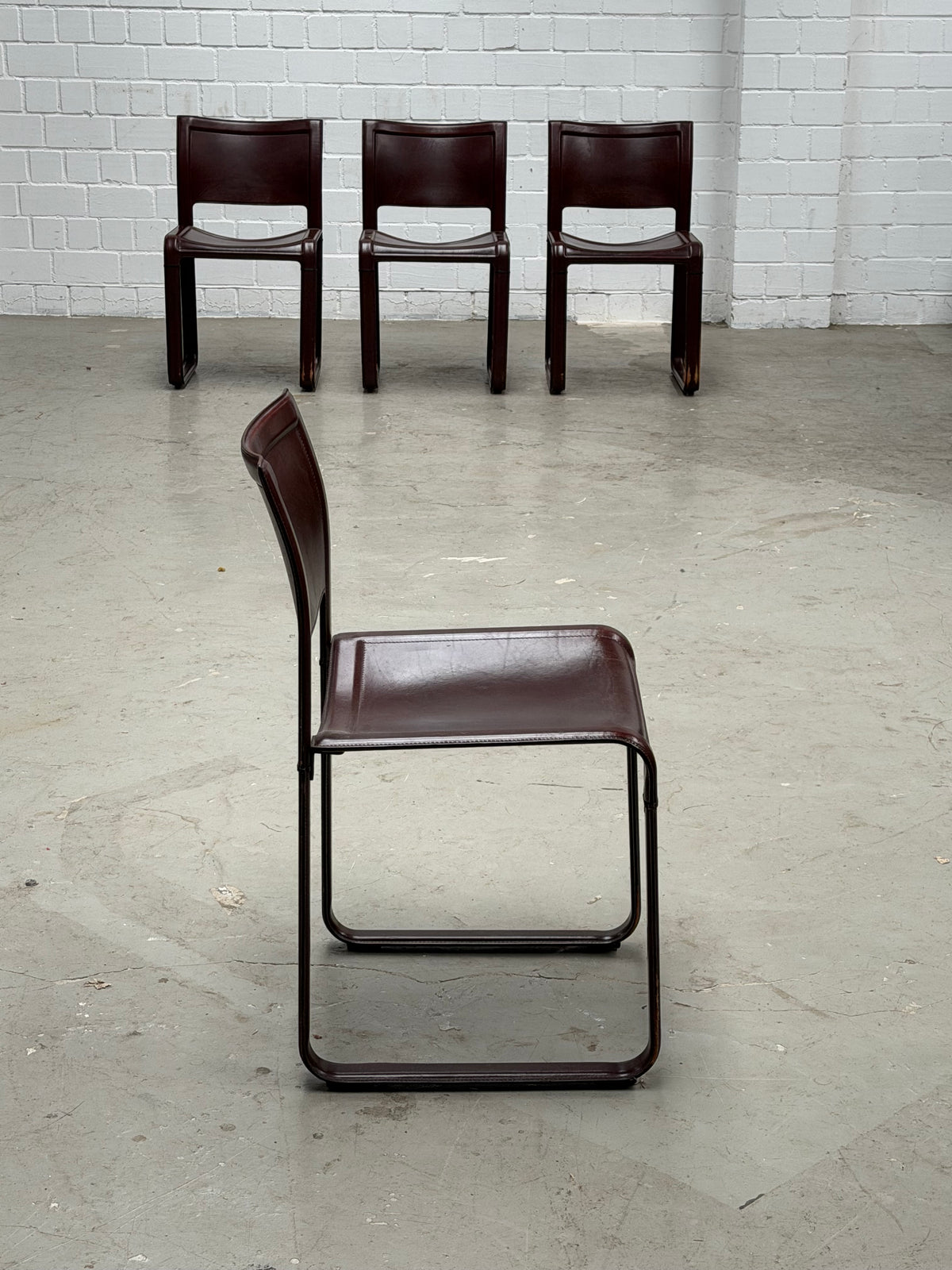 A Set of 4 Matteo Grassi - Sinistra - chairs in Burgundi leather designed by Tito Agnolio